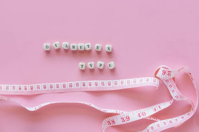 Close-up of diabetes type block letters and measuring tape on pink background.