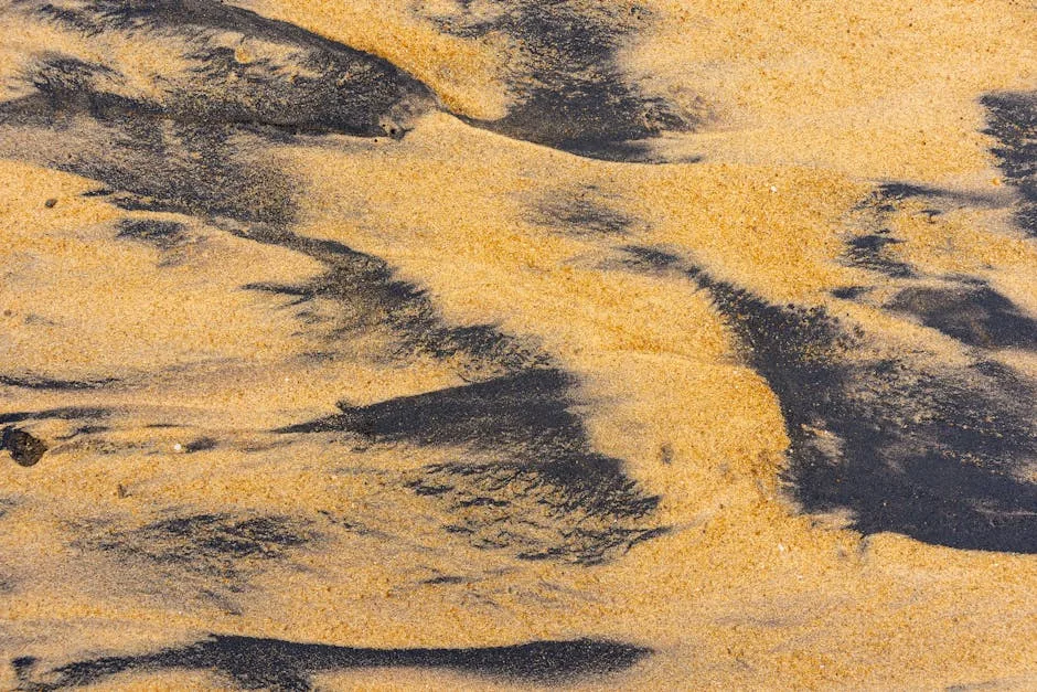 Detailed close-up of sand textures with ilmenite on a beach, highlighting natural patterns.