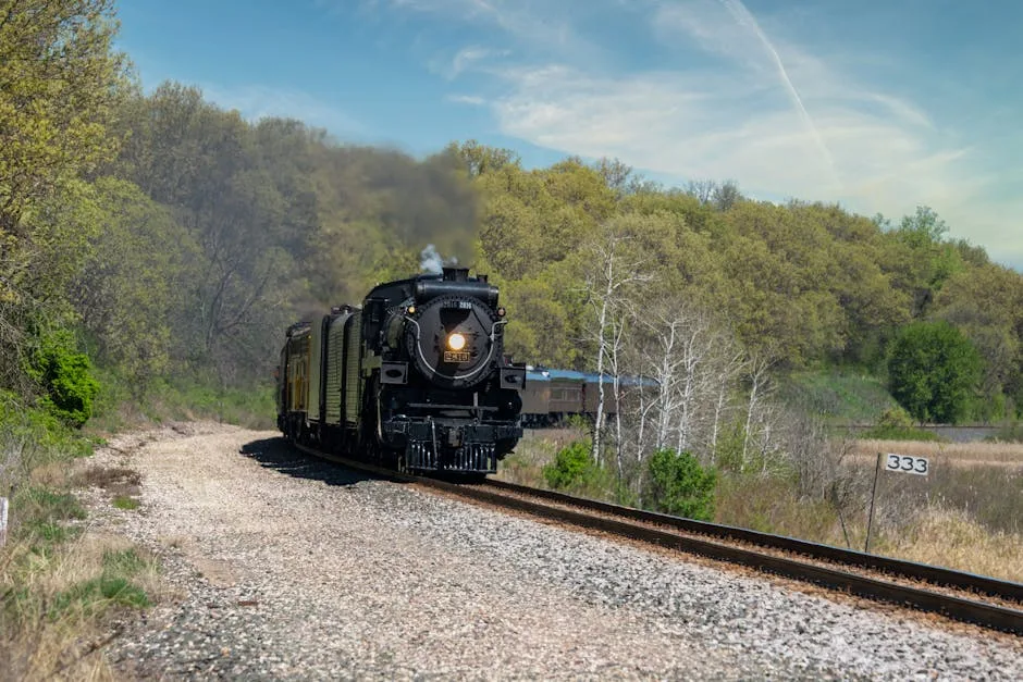 A classic steam locomotive travels through the scenic countryside of Kellogg, MN on a sunny day.